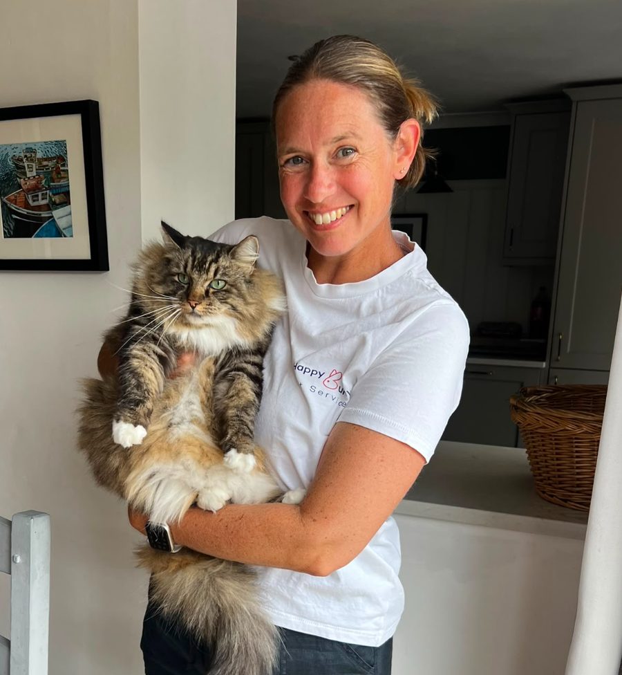 Sue Ralphs of Happy Bunny Pet Services holding a long-haired tabby cat